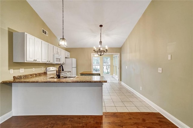209 Jacobs Way, Jasper, GA 30143 - kitchen featuring white appliances, lofted ceiling, white cabinetry, a peninsula, and hanging light fixtures