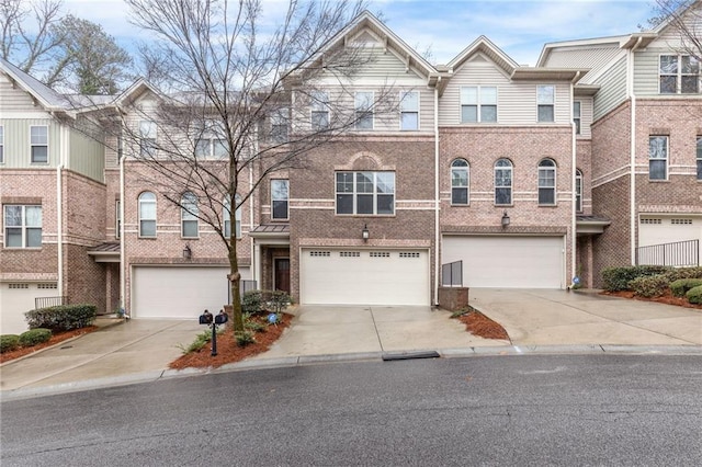 view of property with brick siding, driveway, and an attached garage