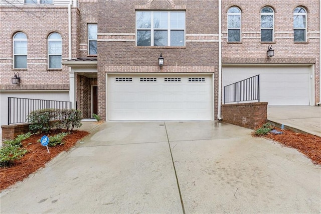 view of property with brick siding, concrete driveway, and an attached garage