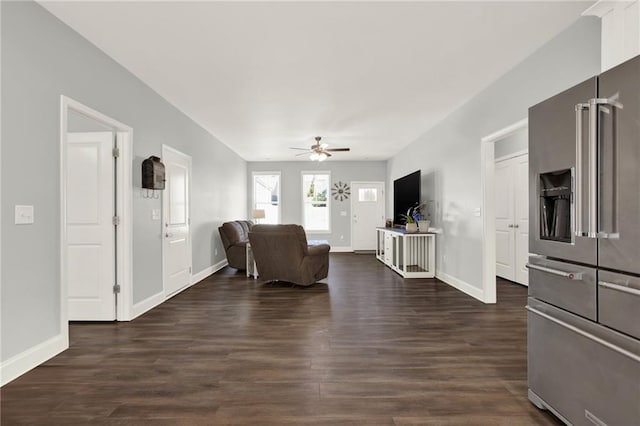 living area with ceiling fan, dark wood-type flooring, and baseboards