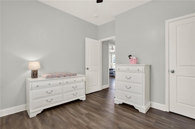 bedroom with a ceiling fan, baseboards, and dark wood-type flooring