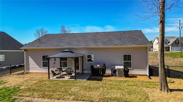 rear view of house featuring a patio, a lawn, a gazebo, and fence