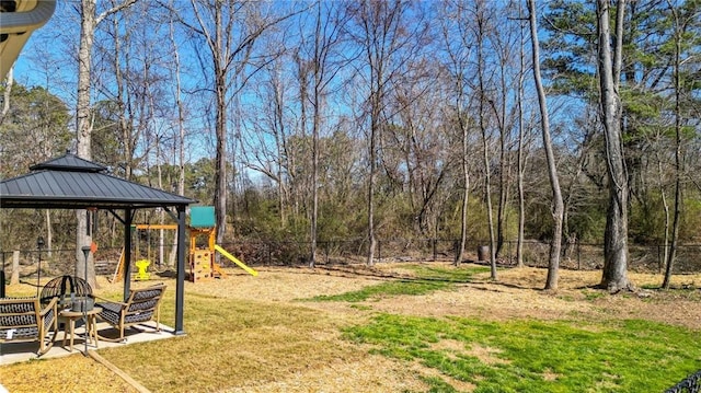 view of yard with a playground, fence, and a gazebo