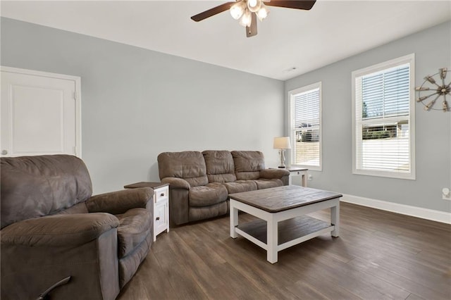 living room with dark wood-style flooring, ceiling fan, and baseboards