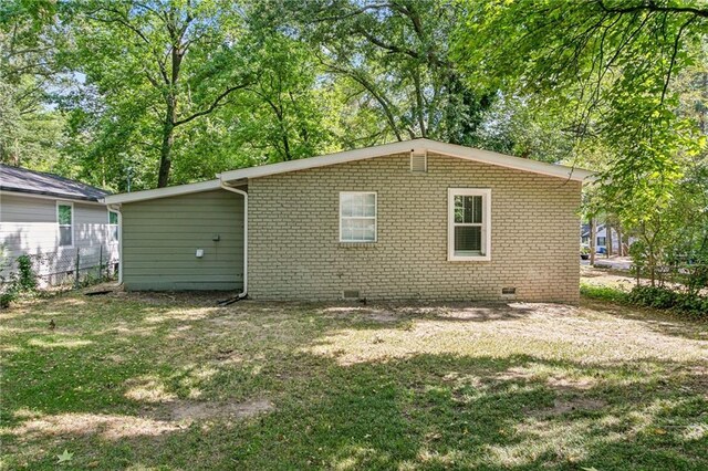 rear view of house featuring a yard