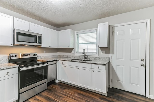 kitchen featuring sink, dark wood-type flooring, white cabinets, and appliances with stainless steel finishes