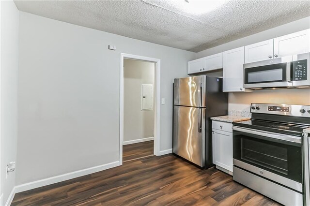 kitchen featuring stainless steel appliances, dark hardwood / wood-style floors, a textured ceiling, and white cabinets