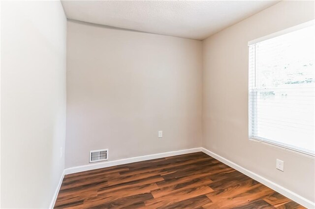 spare room with dark hardwood / wood-style flooring