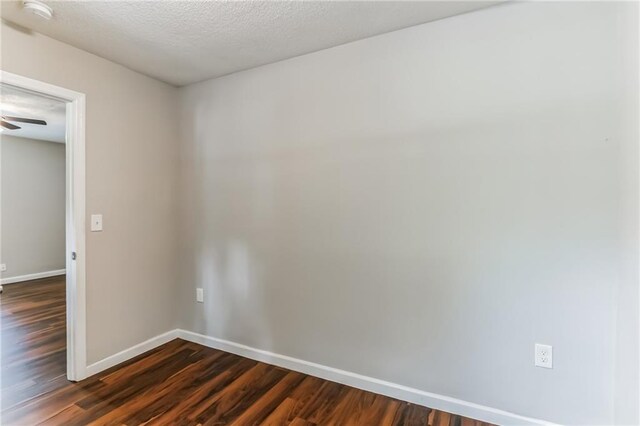 spare room with ceiling fan, dark hardwood / wood-style floors, and a textured ceiling