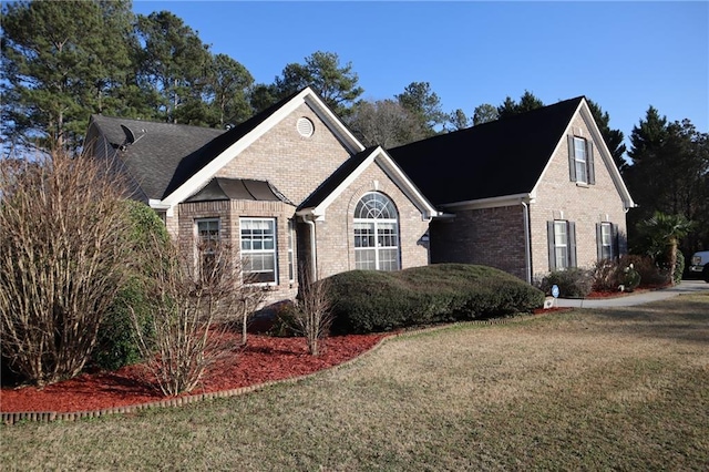 view of front of property featuring brick siding and a front yard