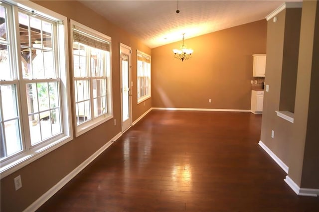 unfurnished dining area featuring baseboards, lofted ceiling, dark wood-style floors, and a chandelier