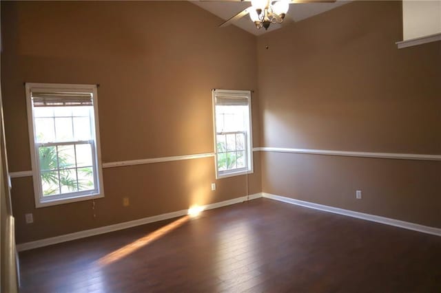 spare room featuring a wealth of natural light, a ceiling fan, baseboards, and wood finished floors