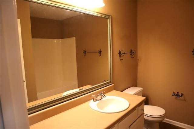 bathroom featuring a shower, toilet, and vanity