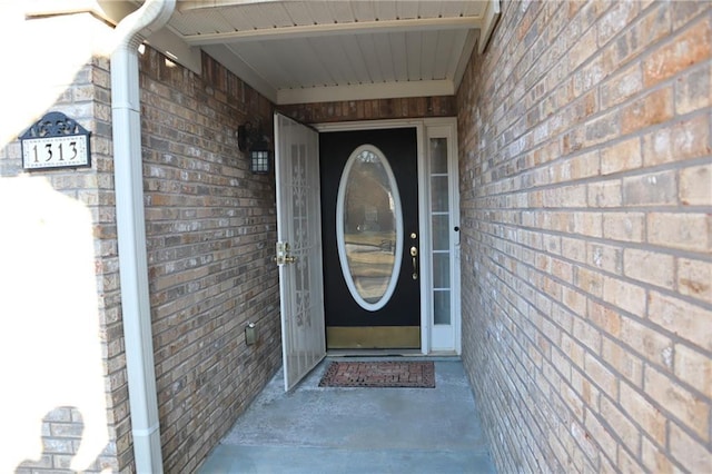 doorway to property with brick siding