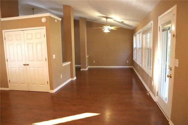 interior space with baseboards, wood finished floors, a ceiling fan, and vaulted ceiling