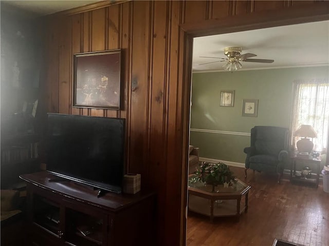 living room featuring hardwood / wood-style flooring, ceiling fan, and ornamental molding