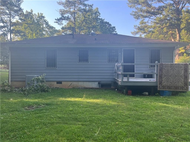 rear view of property with a deck, a yard, and central AC