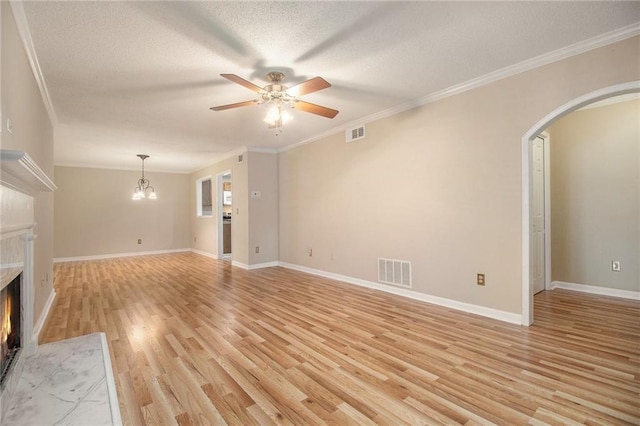 205 Peachtree Forest Ter, Peachtree Corners, GA 30092 - unfurnished living room with a fireplace, arched walkways, light wood-style flooring, a textured ceiling, and a ceiling fan