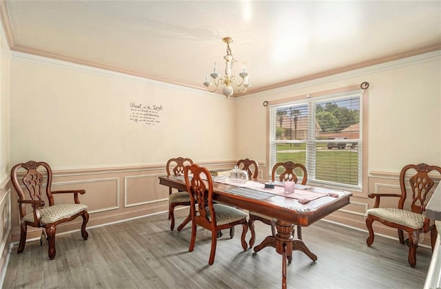 3514 Blackberry Ln SE, Conyers, GA 30094 - dining area featuring a chandelier, ornamental molding, wood finished floors, a wainscoted wall, and a decorative wall