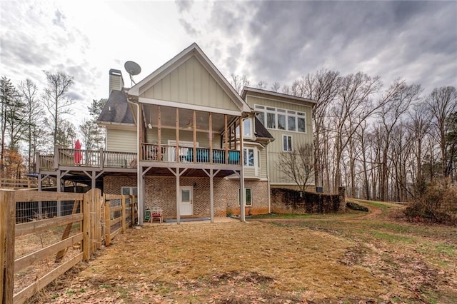 rear view of property with a wooden deck and a sunroom