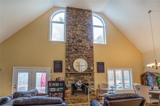 living room with a fireplace, high vaulted ceiling, and an inviting chandelier