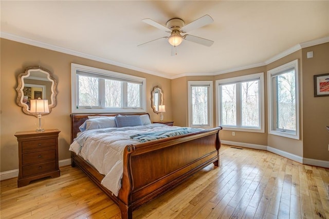 bedroom with light hardwood / wood-style flooring, ceiling fan, multiple windows, and crown molding