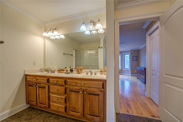 bathroom featuring crown molding, dual sinks, tile floors, and vanity with extensive cabinet space