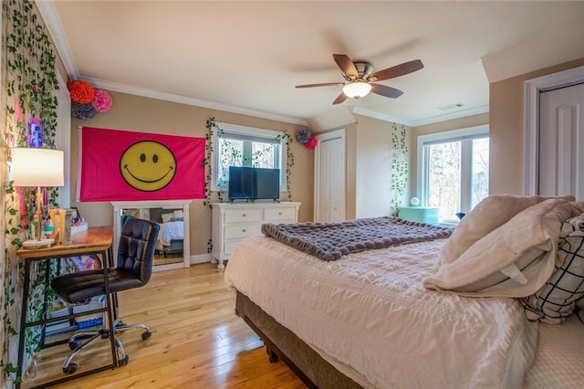 bedroom with multiple windows, crown molding, light wood-type flooring, and ceiling fan