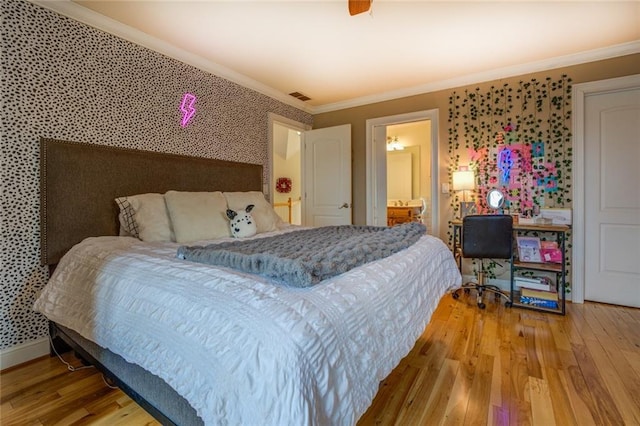 bedroom with ornamental molding, ensuite bathroom, and light hardwood / wood-style floors