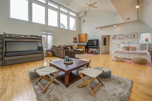 living room with high vaulted ceiling, light hardwood / wood-style floors, and ceiling fan