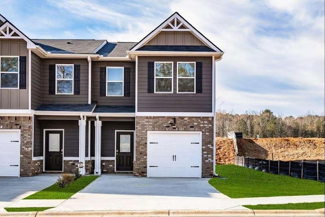 227 Ivey Ter Unit 36, Temple, GA 30179 - view of front of home featuring board and batten siding, driveway, an attached garage, brick siding, and covered porch