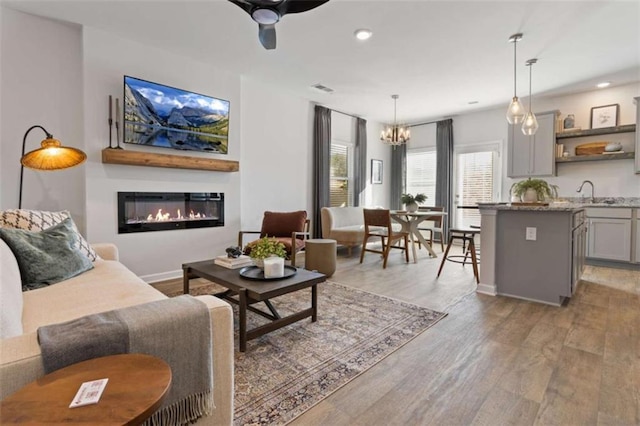 227 Ivey Ter Unit 36, Temple, GA 30179 - living area featuring a chandelier, light wood-type flooring, a glass covered fireplace, recessed lighting, and a ceiling fan