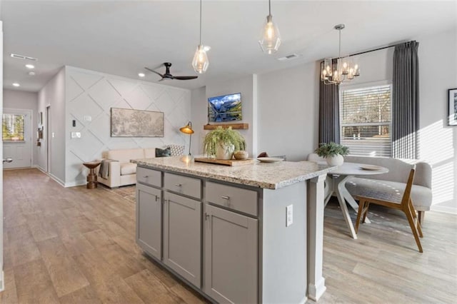 227 Ivey Ter Unit 36, Temple, GA 30179 - kitchen featuring gray cabinetry, light wood-style floors, a center island, a chandelier, and ceiling fan