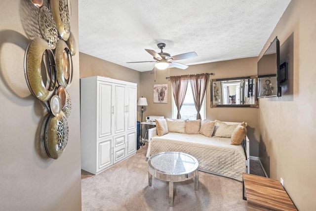 living room featuring light carpet, ceiling fan, and a textured ceiling