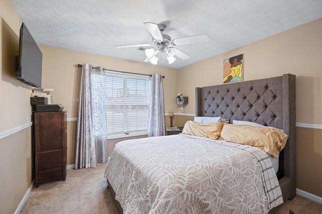 carpeted bedroom with a textured ceiling and ceiling fan