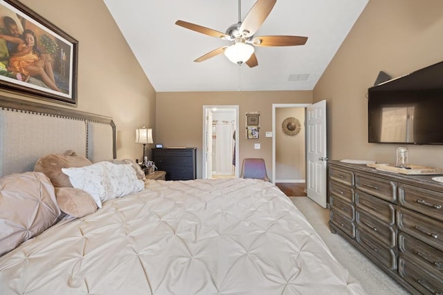 bedroom with ceiling fan, light colored carpet, lofted ceiling, and ensuite bathroom