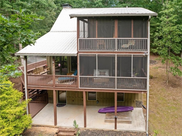 85 Misty Hollow Rdg, Ellijay, GA 30536 - rear view of house with a sunroom, a patio area, a metal roof, a deck, and a chimney