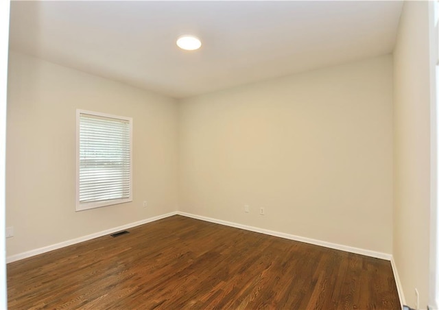 unfurnished room with dark hardwood / wood-style flooring