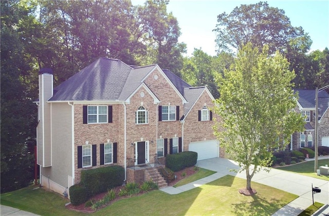 colonial home featuring a front yard and a garage