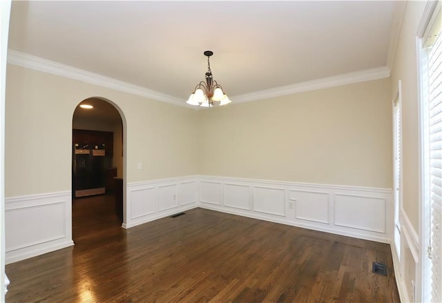 unfurnished room featuring dark hardwood / wood-style flooring, crown molding, and a chandelier