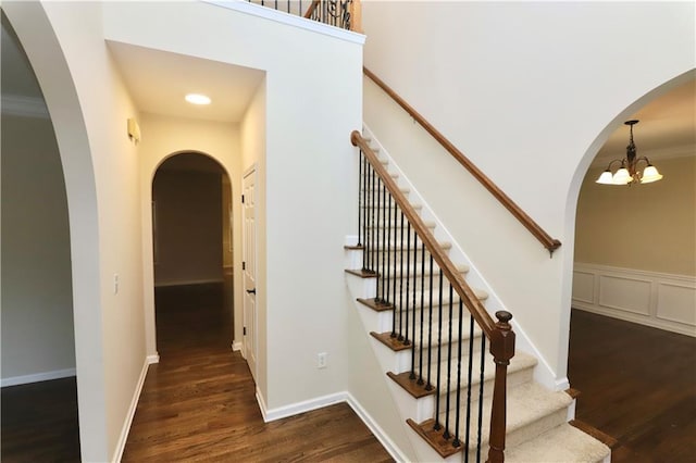 stairs featuring hardwood / wood-style floors and a chandelier