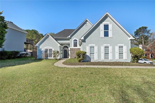 back of house featuring stucco siding, french doors, a yard, and fence