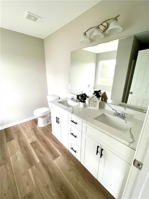 bathroom with hardwood / wood-style flooring, vanity, and toilet