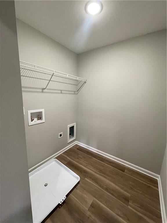 laundry area featuring electric dryer hookup, hookup for a washing machine, and dark hardwood / wood-style flooring