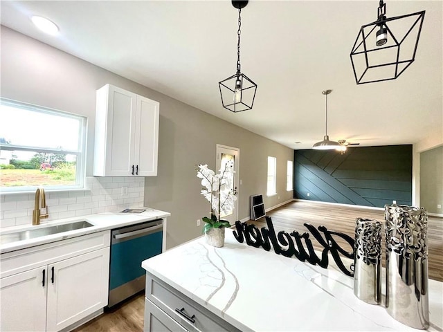 kitchen featuring decorative light fixtures, white cabinetry, dishwasher, sink, and decorative backsplash