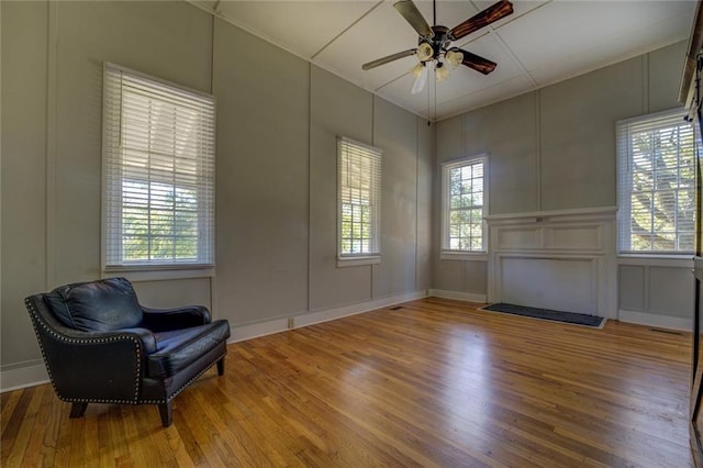 living area featuring hardwood / wood-style flooring and ceiling fan