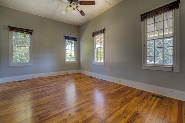 unfurnished room with a textured ceiling, wood-type flooring, and ceiling fan
