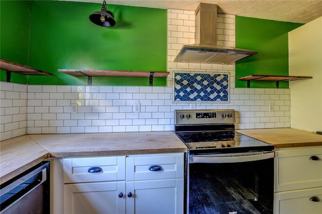 kitchen featuring tasteful backsplash, wall chimney range hood, butcher block countertops, white cabinetry, and stainless steel electric stove
