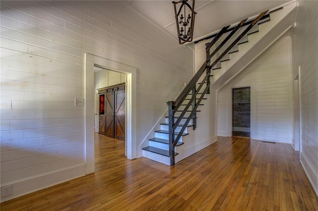 staircase featuring a barn door and hardwood / wood-style floors