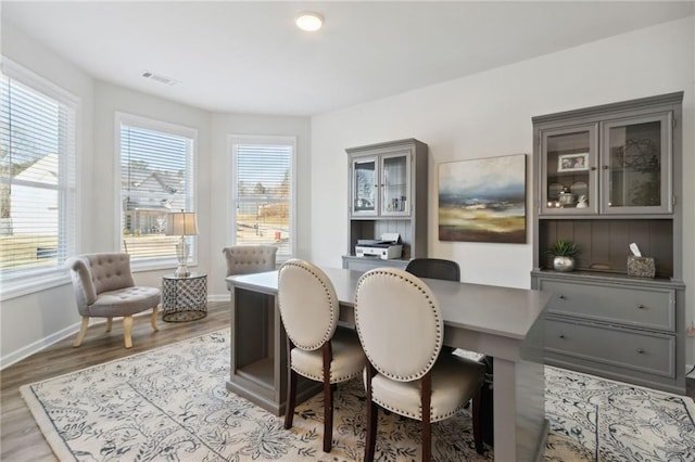 office space with baseboards, wood finished floors, and visible vents